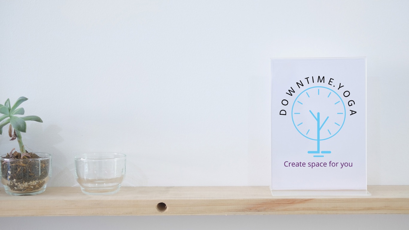 A shelf with a small succulent plant, a clear glass bowl, and a sign for 'DOWNTIME.YOGA' that reads 'Create space for you.'
